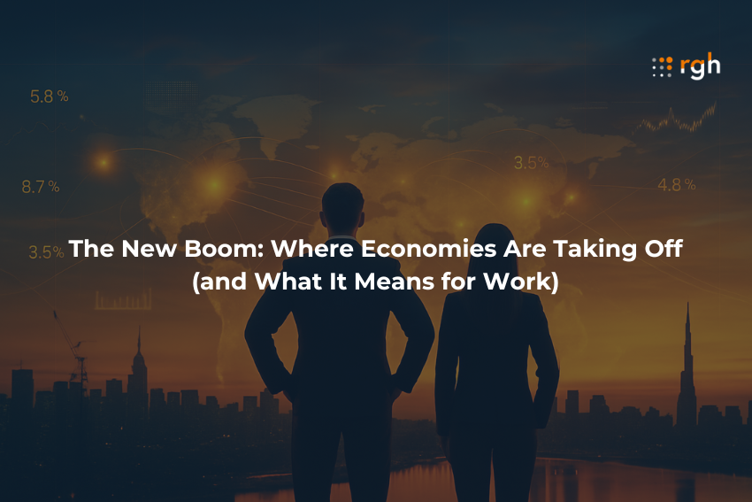 A man and woman in business attire stand on a rooftop overlooking a glowing city at sunset, facing a digital world map representing booming global economies.